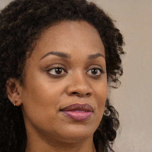 Joyful black young-adult female with medium  brown hair and brown eyes