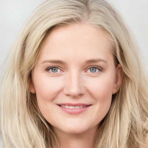 Joyful white young-adult female with long  brown hair and blue eyes