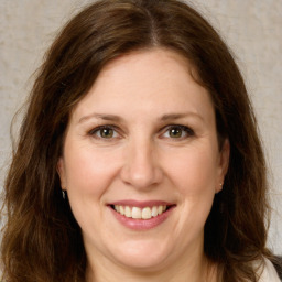 Joyful white young-adult female with long  brown hair and green eyes