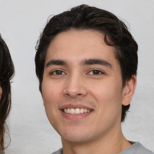 Joyful white young-adult male with medium  brown hair and brown eyes