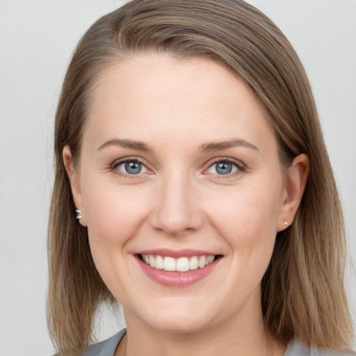 Joyful white young-adult female with medium  brown hair and grey eyes