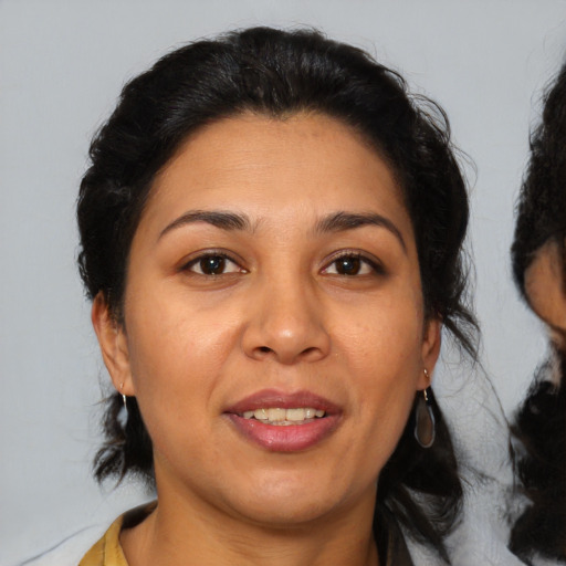 Joyful latino adult female with medium  brown hair and brown eyes