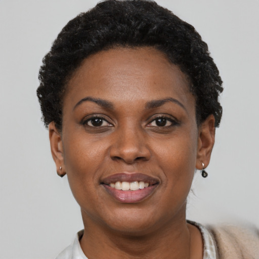 Joyful black young-adult female with short  black hair and brown eyes