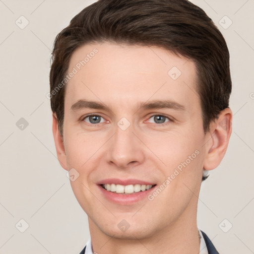 Joyful white young-adult male with short  brown hair and grey eyes