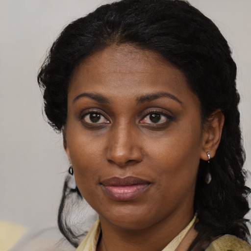 Joyful black young-adult female with medium  brown hair and brown eyes