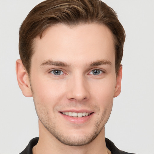 Joyful white young-adult male with short  brown hair and grey eyes