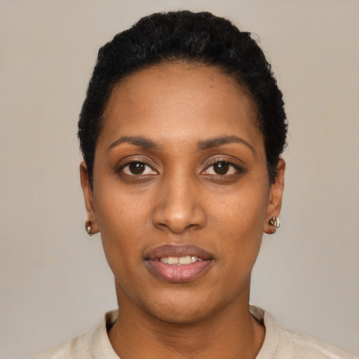 Joyful black young-adult female with short  black hair and brown eyes
