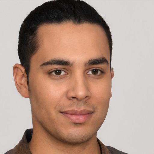 Joyful latino young-adult male with short  brown hair and brown eyes