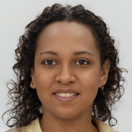 Joyful black young-adult female with long  brown hair and brown eyes