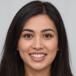 Joyful latino young-adult female with long  brown hair and brown eyes