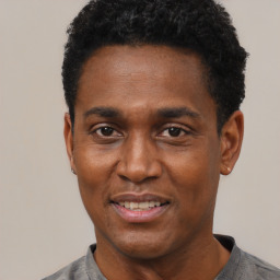 Joyful black adult male with short  black hair and brown eyes