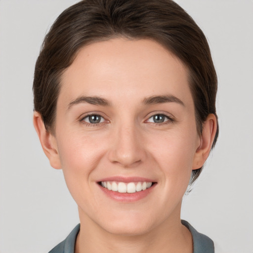 Joyful white young-adult female with short  brown hair and grey eyes