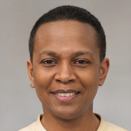 Joyful black adult male with short  black hair and brown eyes