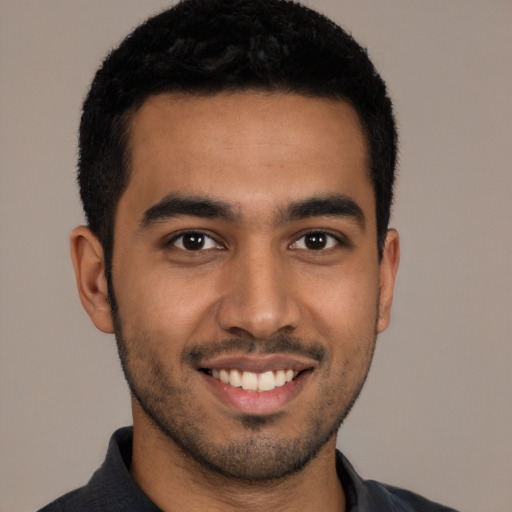 Joyful latino young-adult male with short  black hair and brown eyes