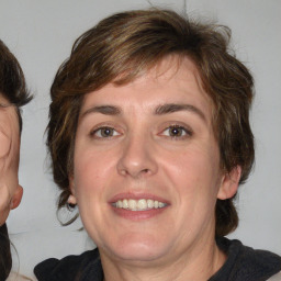 Joyful white adult female with medium  brown hair and blue eyes