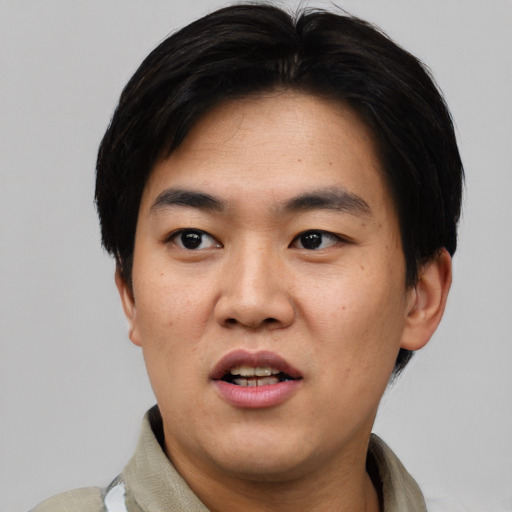 Joyful asian young-adult male with short  black hair and brown eyes