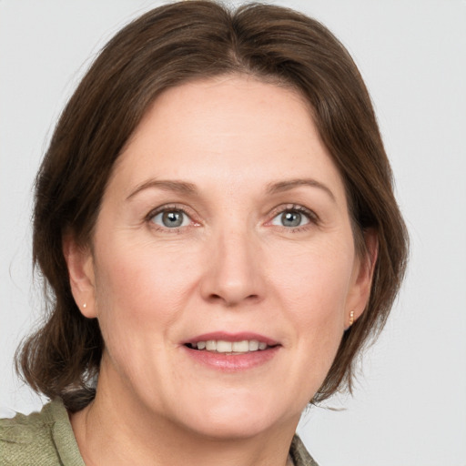 Joyful white adult female with medium  brown hair and grey eyes