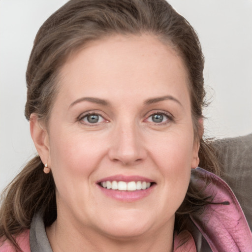 Joyful white young-adult female with medium  brown hair and grey eyes