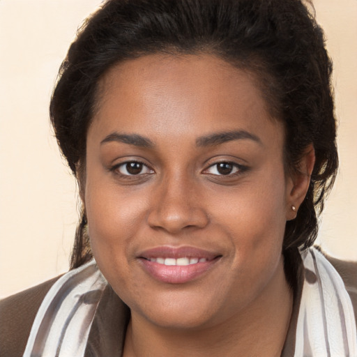 Joyful black young-adult female with long  brown hair and brown eyes