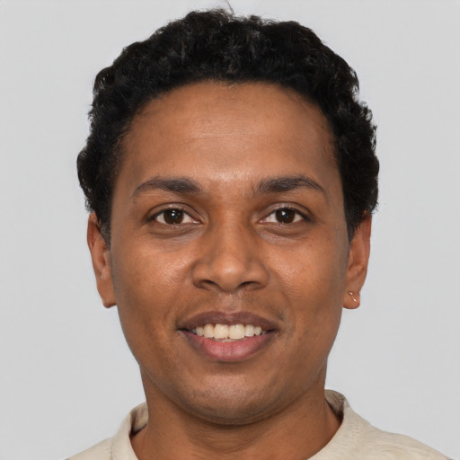Joyful black young-adult male with short  black hair and brown eyes