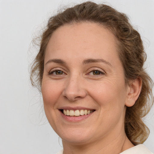 Joyful white adult female with medium  brown hair and grey eyes