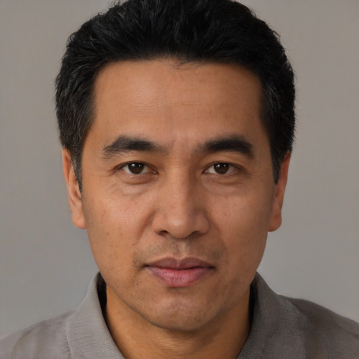 Joyful asian adult male with short  black hair and brown eyes