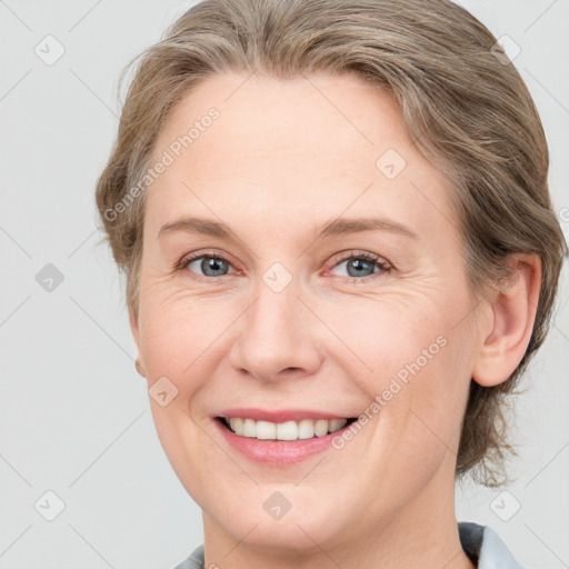 Joyful white young-adult female with medium  brown hair and blue eyes