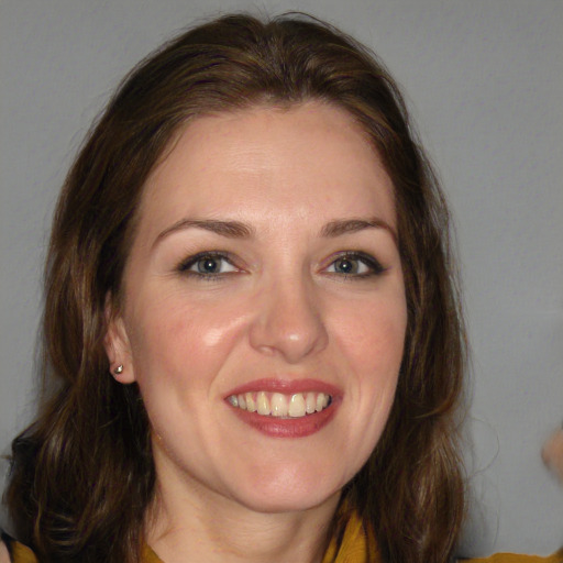 Joyful white young-adult female with long  brown hair and blue eyes