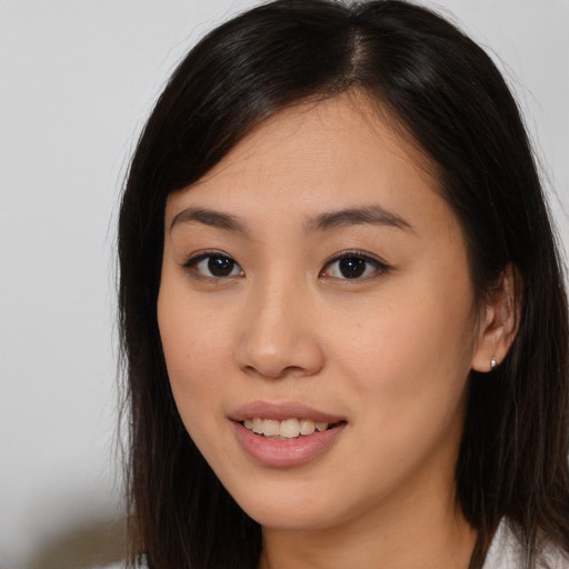 Joyful asian young-adult female with long  brown hair and brown eyes