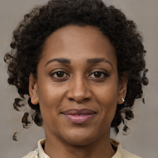Joyful black adult female with medium  brown hair and brown eyes