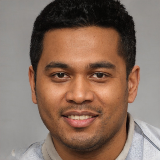 Joyful black young-adult male with short  black hair and brown eyes
