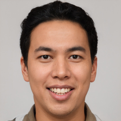 Joyful latino young-adult male with short  brown hair and brown eyes