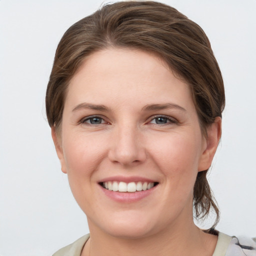 Joyful white young-adult female with medium  brown hair and grey eyes