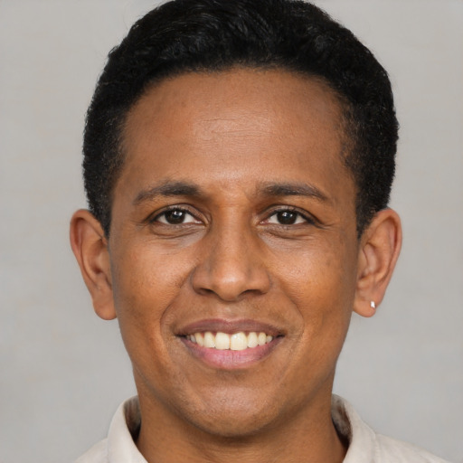Joyful latino young-adult male with short  black hair and brown eyes