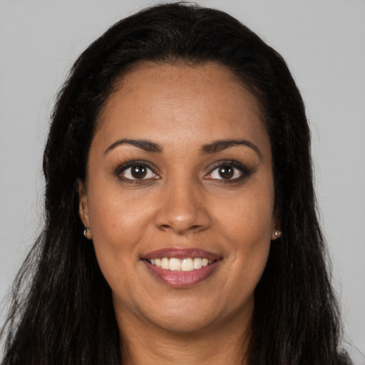 Joyful black young-adult female with long  brown hair and brown eyes