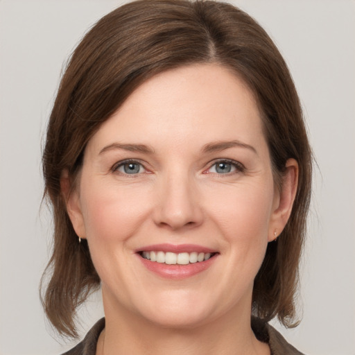 Joyful white young-adult female with medium  brown hair and grey eyes