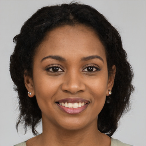 Joyful black young-adult female with long  brown hair and brown eyes