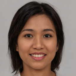 Joyful asian young-adult female with medium  brown hair and brown eyes