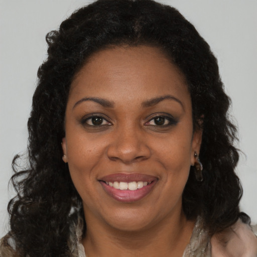 Joyful black young-adult female with long  brown hair and brown eyes