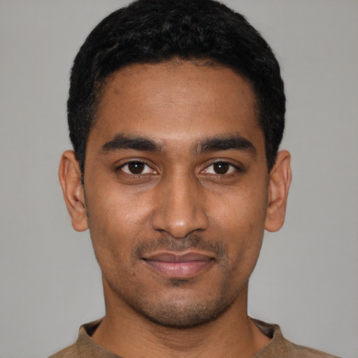 Joyful black young-adult male with short  black hair and brown eyes