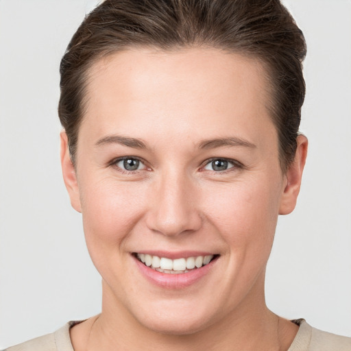 Joyful white young-adult female with short  brown hair and grey eyes