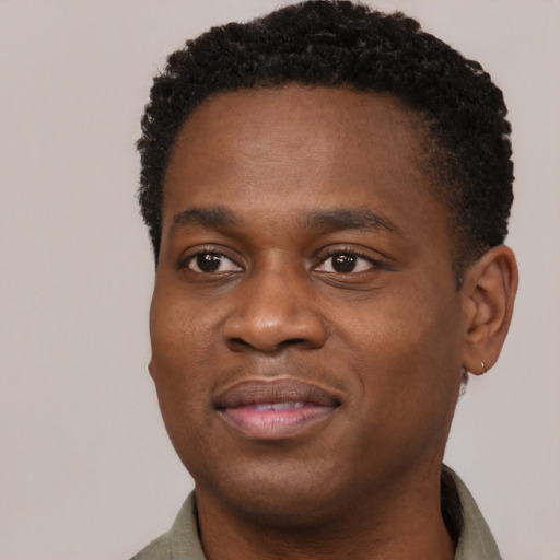 Joyful black young-adult male with short  brown hair and brown eyes