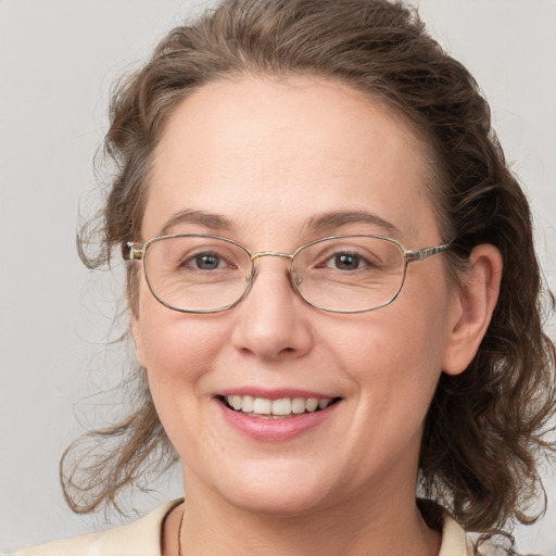 Joyful white adult female with medium  brown hair and grey eyes