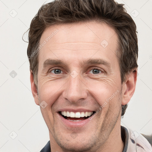 Joyful white adult male with short  brown hair and grey eyes