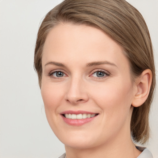 Joyful white young-adult female with medium  brown hair and grey eyes