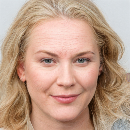 Joyful white adult female with long  brown hair and blue eyes