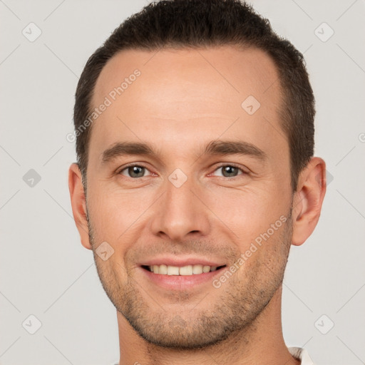 Joyful white young-adult male with short  brown hair and brown eyes