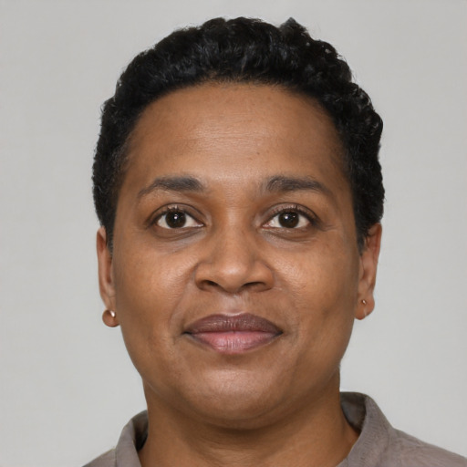 Joyful black adult female with short  black hair and brown eyes