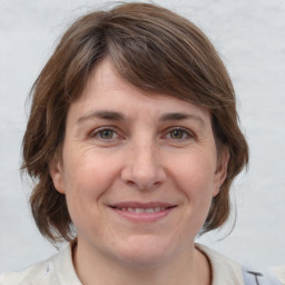 Joyful white adult female with medium  brown hair and grey eyes