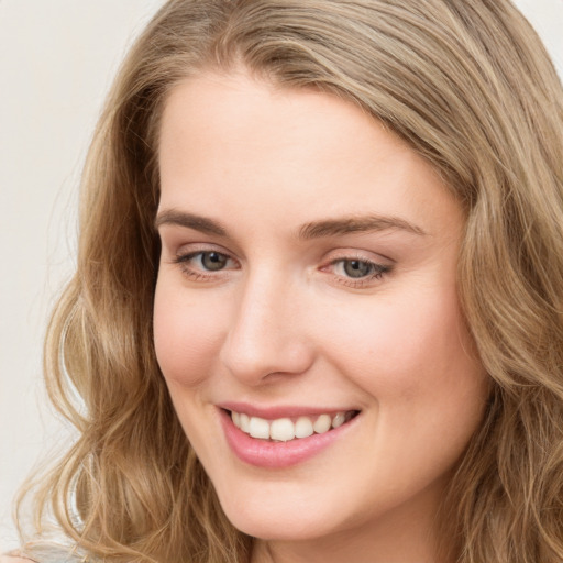 Joyful white young-adult female with long  brown hair and blue eyes